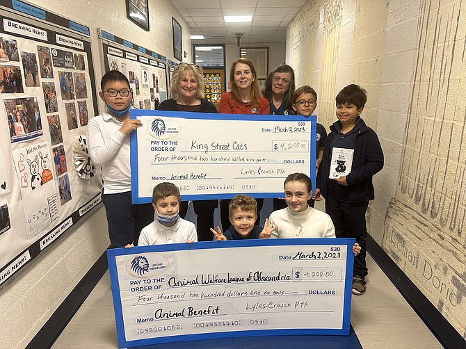 Students at Lyles-Crouch Traditional Academy hold checks representing more than $8,000 raised for the benefit of the Animal Welfare League of Alexandria and King Street Cats. In back are Donna Eisenman of King Street Cats, Stella Hanly of AWLA and Lyles-Crouch Traditional Academy principal Patricia Zizzios.