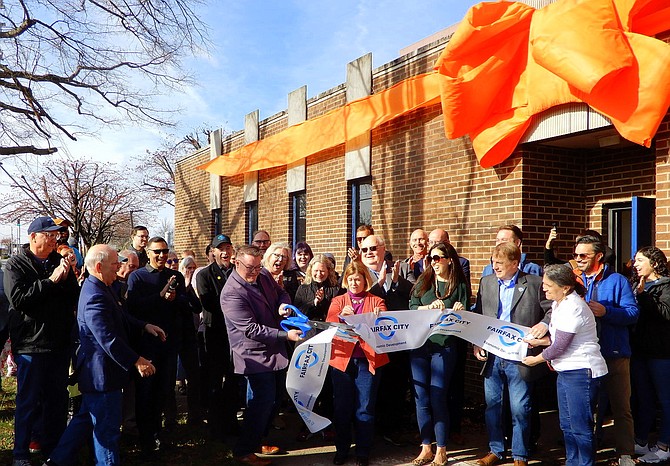 Bradley Matthews cuts the ribbon while (from left) Catherine Read, Kathleen Paley, David Meyer and Jeanne Marshall hold it.