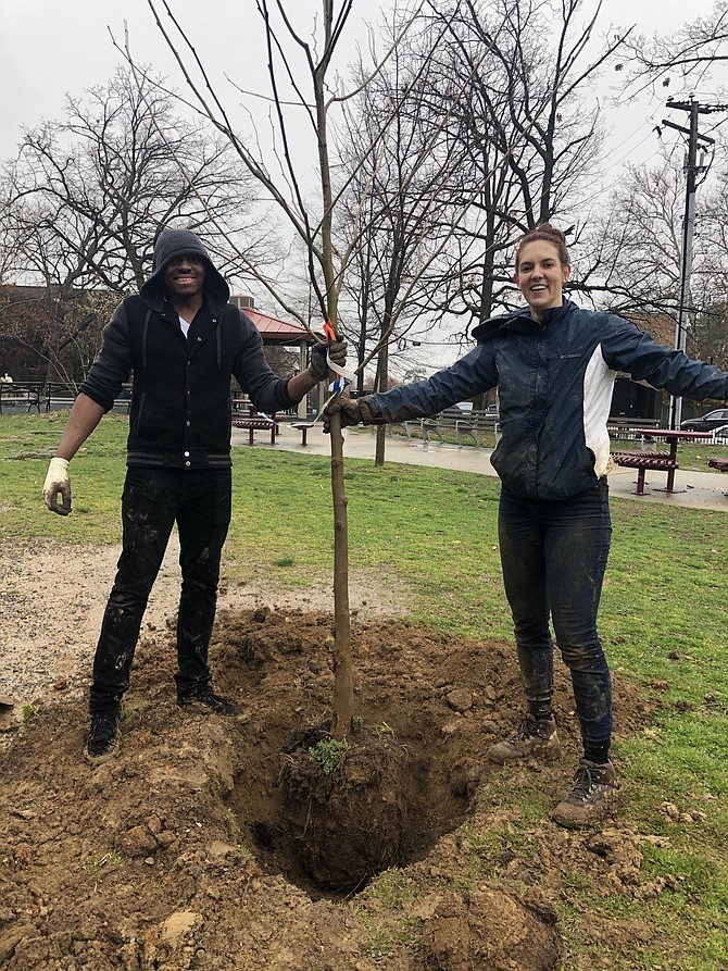 Meghan Mitchell (right) and Nazaire Kunlipe, stand next to the tree they just wrestled from its root wrap and rolled into the hole they dug despite the wet, compacted, stoney Virginia clay. The native Sycamore will offer shade to generations to come. Mitchell is a graduate assistant for the Saints Service Network, part of the Office of Volunteer Opportunity, getting her degree in school counseling.