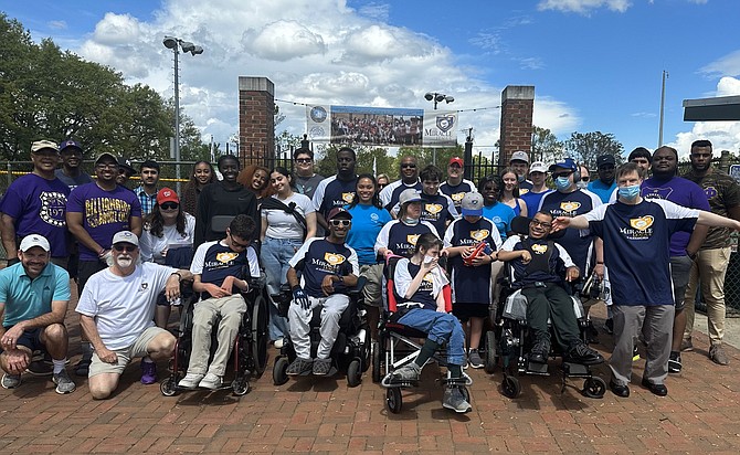 Participants and volunteers in the Miracle League of Alexandria gather for a group photo to celebrate opening day April 15 at the Kelley Cares Miracle Field at the Nannie J. Lee Recreation Center.