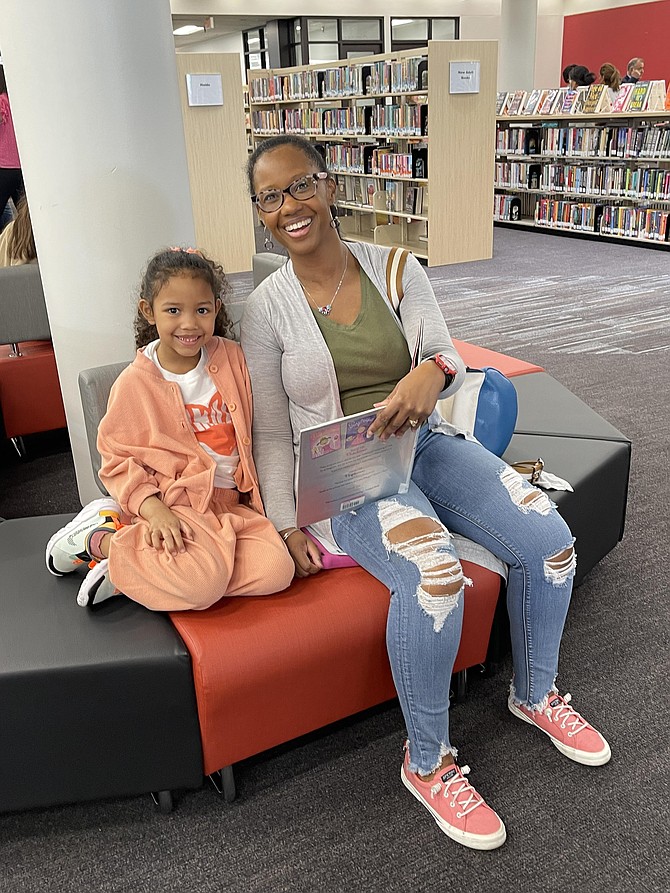 Lakeisha Flores and daughter Lelolai Flores, 6, enjoy reading Silverlicious underneath skylighting at the newly refurbished Potomac Library.