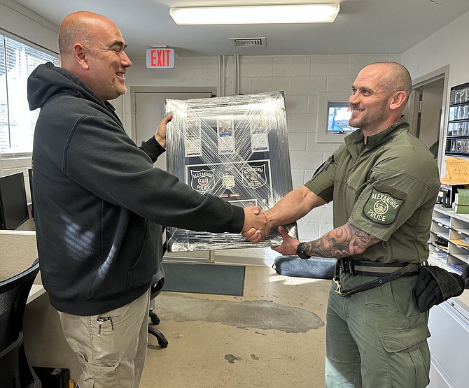 APD Sgt. Kyle Russel, right, presents a shadow box to Officer Brian Fromm in appreciation of the service of K9s Odin and Zeus March 29 at the K9 kennels at the Lee Center.