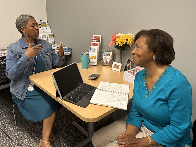 Division of Aging and Adult Services representative Pamela Austin, left, speaks with Deborah Tompkins Johnson about caregiving options for older adults.