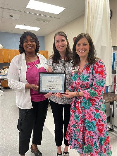 Dr. Laura Evans, center, presents a certificate of appreciation May 11 to Florence Debra, LNHA, RN, and Donna Shaw, LNHA, RN, of Woodbine Rehabilitation and Healthcare Center in recognition of the facility’s work-based learning opportunities for high school students.