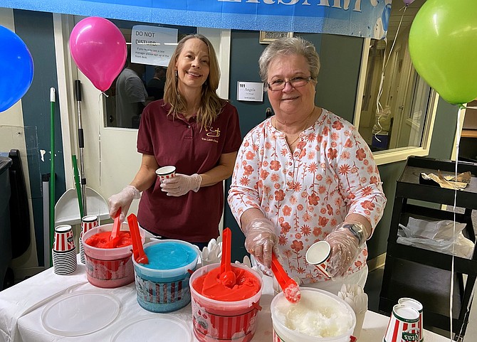 From left, Finance and Human Resources Director Pamela Carey and Operations Administrative Assistant Barb DeLisa dishing up Rita’s Italian Ice.
