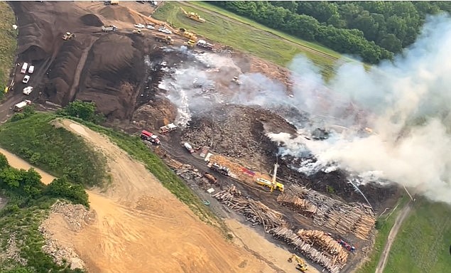 From the air, smoke can be seen rising above the landfill.