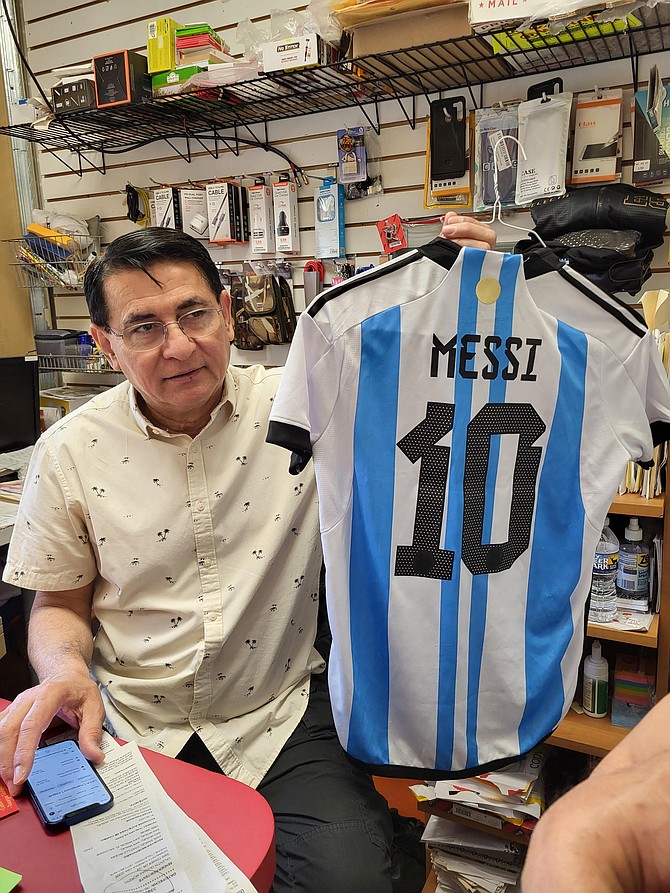 Jose Machuca with one of the soccer jerseys — this one of soccer star Lionel Messi — he displays at Machu Pollo.