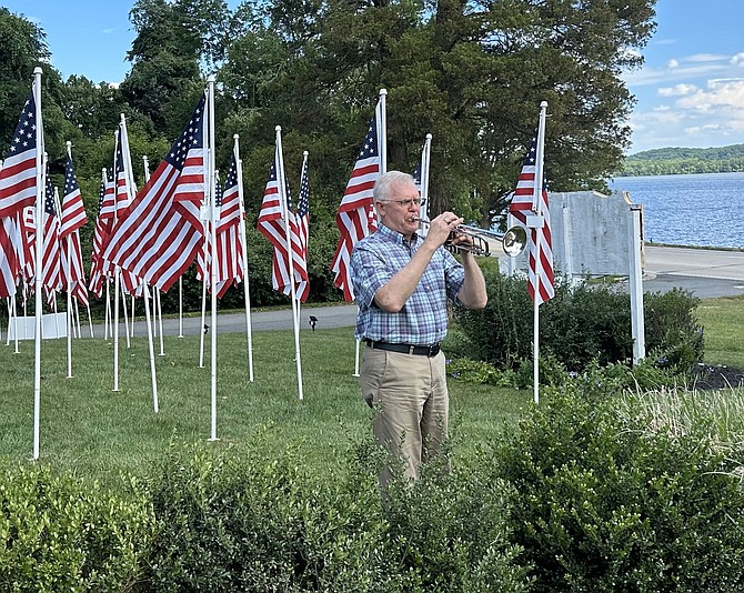 Paul Johnson performs Taps to close the opening day ceremony of the Flags for Heroes program June 25 at Cedar Knoll Restaurant. The flags will be on display through July 8.