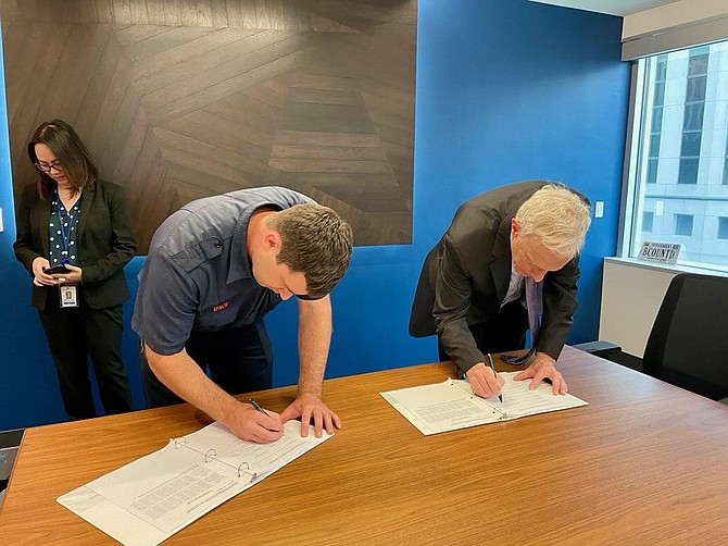 Brian Lynch, president of Arlington Professional Firefighters and Paramedics Association, Local 2800 of the International Association of Fire Fighters, and County Manager Mark Schwartz sign the collective bargaining agreement.