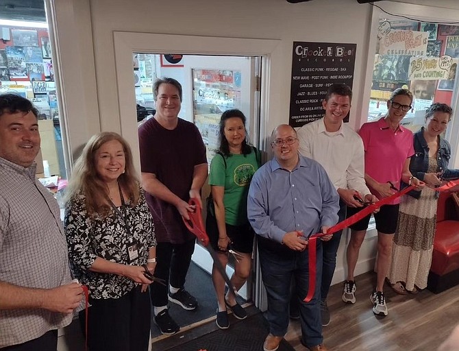 Crooked Beat Records owners Bill and Helen Daly, third and fourth from left, celebrate with local officials and business leaders July 7 at the grand opening celebration of the new Del Ray location in the basement of 2417 Mount Vernon Avenue.