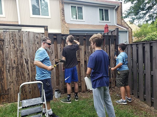 Scouts of BSA Troop 572 and assistant scoutmaster Jason Matchett work on the fence. The troop is chartered by Our Lady of Hope in Potomac Falls, Va.