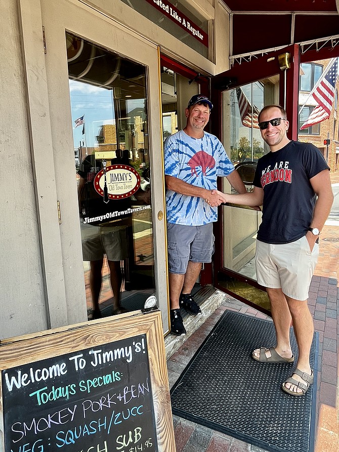 Jimmy Cirrito, owner of Jimmy’s Old Town Tavern greets Fairfax County Public School teacher Gabe Segal who is holding Cheers for Children at the tavern on Aug. 17 to raise funds to pay FCPS student meal debt.