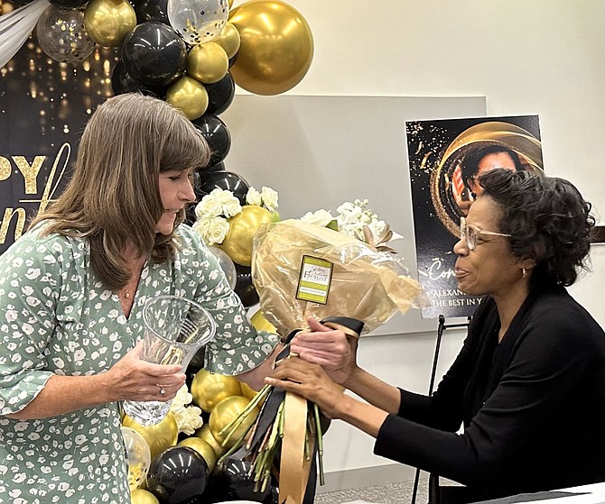 Kate Garvey, left, presents flowers to former Deputy City Manager Debra Collins at a retirement celebration Aug. 17 at the Redella S. Pepper Community Resource Center building.