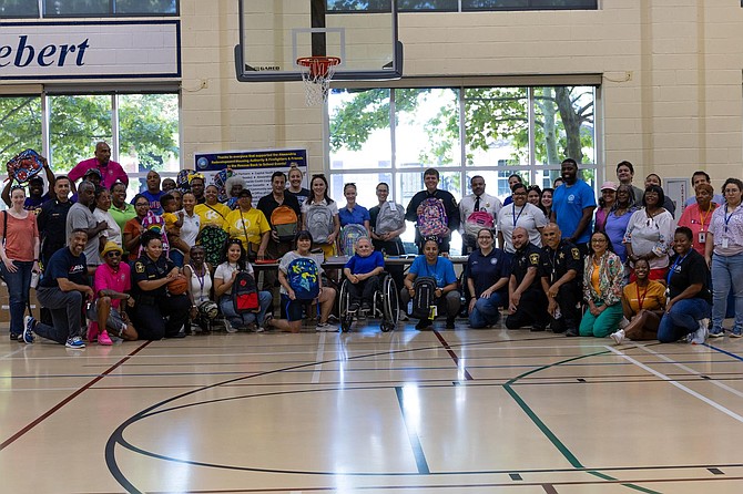Volunteers pose for a group photo at the Firefighters and Friends backpack distribution Aug. 19 at Charles Houston Recreation Center.