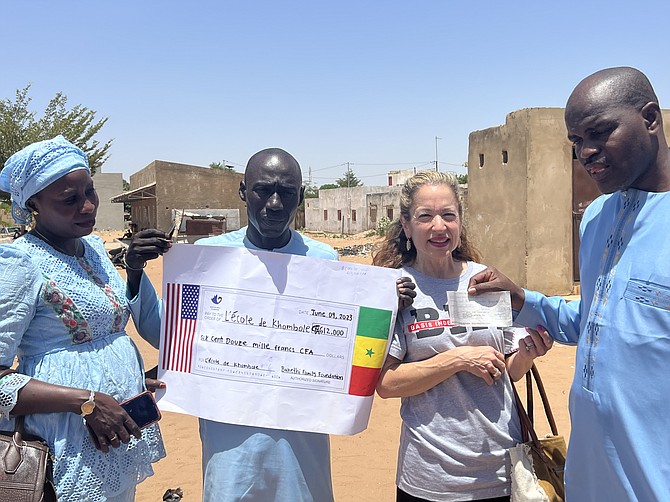 From left, Madame Ngom, head mistress, joins Abdoulaye Diouf, head of school at École 6, Elisabeth Sèye, French teacher at BASIS Independent McLean, and Mamadou Sellou Diallo of Le Bentenier Groupe Scolaire de Khombole for the check presentation.