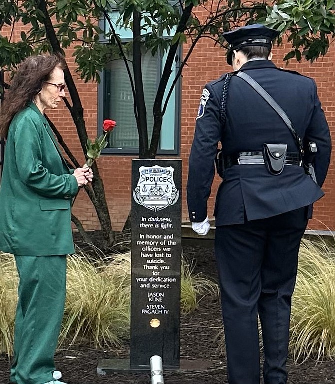 Sandy Colantuoni, left, prepares to place a rose at the APD Suicide Memorial in honor of her son Steven Pagach IV, who died in 2011.