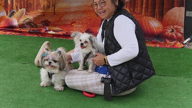 It takes whistling, cajoling and exasperation but finally the Shih Tzu “Apple” and the Chihuahua “Koko” decide to smile along with their owner Kien Vuong for their pet portrait at Paws on the Pike Saturday, Sept. 30. Alex Sakes, freelance photographer hired for the event, says he is booked solid from 1-5 pm with appointments.
