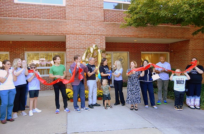 Celebrating the recovery center’s ribbon cutting: In the middle (from left) are Fairfax City Councilmembers Billy Bates (green shirt) and Jon Stehle, CAF Board Chairman Mark Atwood, Ginny Atwood Lovitt, Shelly Young and Fairfax Mayor Catherine Read.