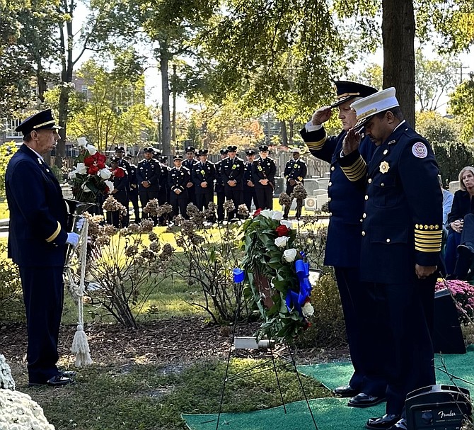 Alexandria Fire Chief Corey Smedley, right, and Alexandria Volunteer Fire Department president Jay Johnson salute after placing a wreath at the Fallen Firefighters Memorial Oct. 13 at Ivy Hill Cemetery.