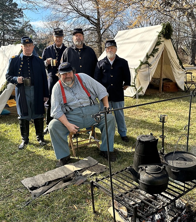 Reenactor Matthew Devor, seated, is surrounded by fellow cannoneers of the 1st Connecticut Light during the Civil War Christmas in Camp Dec. 9 at Fort Ward Museum.
