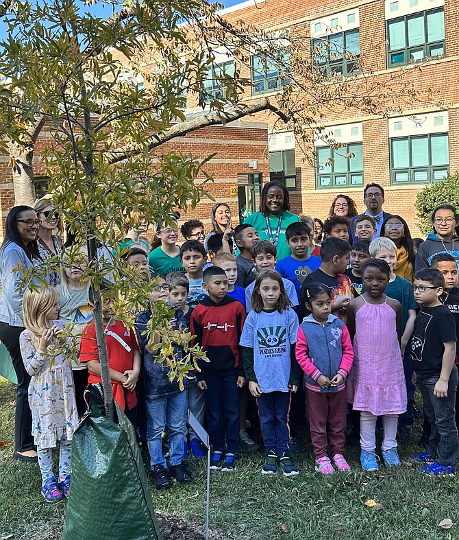ACPS superintendent Melanie Kay-Wyatt, left, stands with Charles Barrett Elementary School students and staff in front of the newly planted willow oak tree Oct. 25 to celebrate the school’s 80th anniversary.
