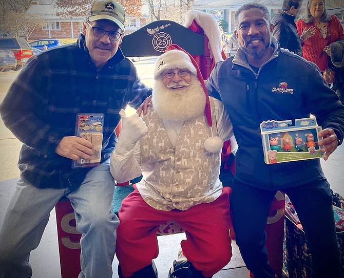 Firefighters and Friends founder Willie Bailey, right, and longtime supporter Bruce Witucki enjoy a visit with Santa, aka firefighter Lt. David Saunders, Dec. 11 at Station 11 in Penn Daw.