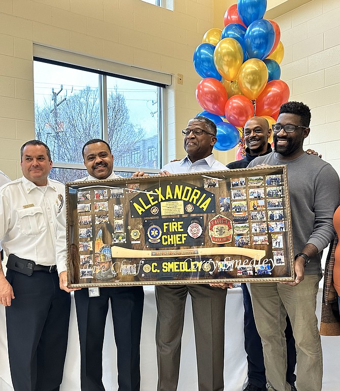Fire Chief Corey Smedley, second from left, poses for a photo after being presented with a farewell shadow box at his retirement celebration Jan. 9 at Charles Houston Recreation Center.