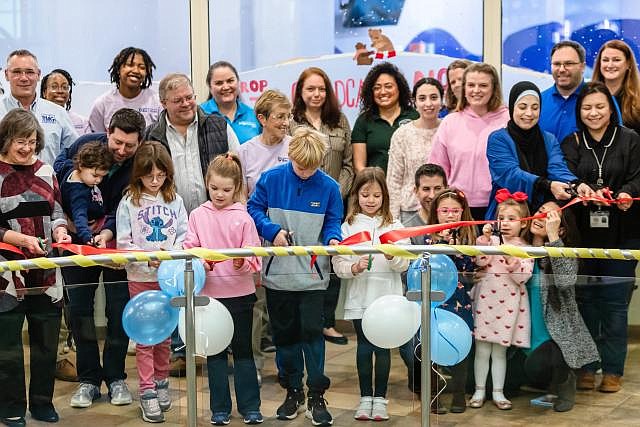 More than a dozen kids, joined by their parents, celebrate the opening of a brand-new space at Cub Run Rec Center