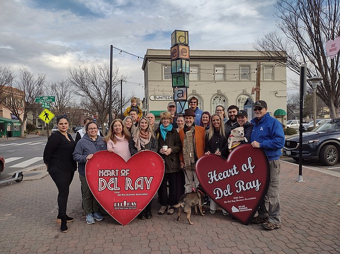Representatives of the Del Ray Business Association gather in Pat Miller Neighborhood Square to present the 2024 Heart of Del Ray Award to The Dog Store and the Duncan Library. It is the first year that the annual award was shared between two businesses.