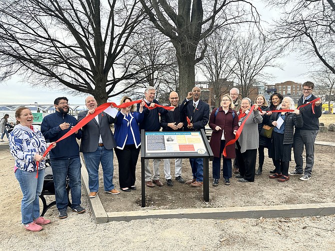 Mayor Justin Wilson, center, flanked by U.S. Rep. Don Beyer and civic leader McArthur Myers, celebrates following the ribbon cutting to open the African American Heritage Trail South Route Feb. 10 at Waterfront Park.