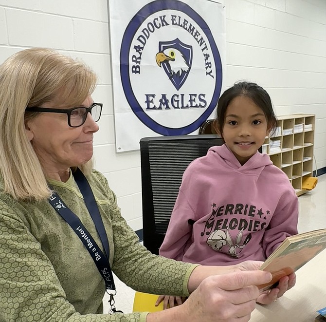 Volunteer reader Elaine Runkle, reading with Jeanyne Rhaigne Tabao , says “sessions are a very good way to pass on the love of reading.”