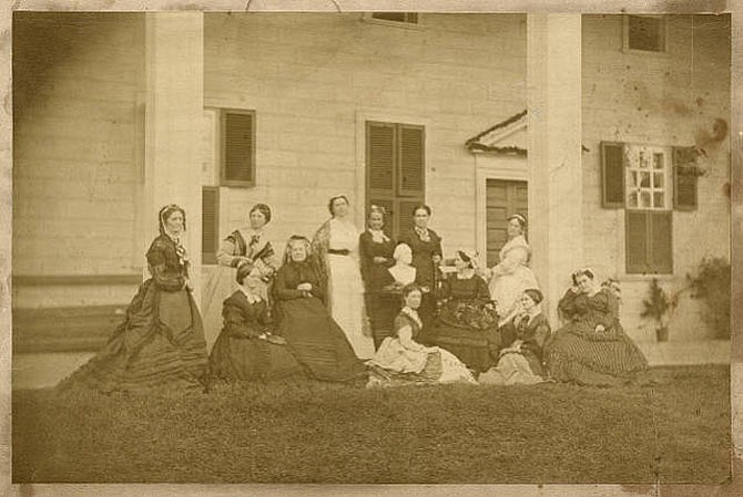 In 1870, members of the Mount Vernon Ladies' Association pose for a photograph near the east front of the Mount Vernon Mansion. Left to right,standing: Mrs. Barry, Vice Regent for Illinois; Mrs. Walker, Vice Regent for North Carolina; Mrs. Washington, Vice Regent for West Virginia; Mrs. Halsted, Vice Regent for New Jersey; Mrs. Emory, Vice Regent for District of Columbia; Mrs. Chace, Vice Regent for Rhode Island. Left to right seated: Mrs. Mitchell, Vice Regent for Wisconsin; Mrs. Brooks, Vice Regent for New York; Mrs. Sweat, Vice Regent for Maine; Miss Cunningham; Regent; Mrs. Comegys, Vice Regent for Delaware; Mrs. Eve, Vice Regent for Georgia.