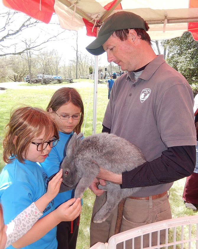 Brothers Parker, left, and Chase Mulholland, pet baby bunny Fern held by Frying Pan Park’s Paul Nicholson at a past Earth Day.
