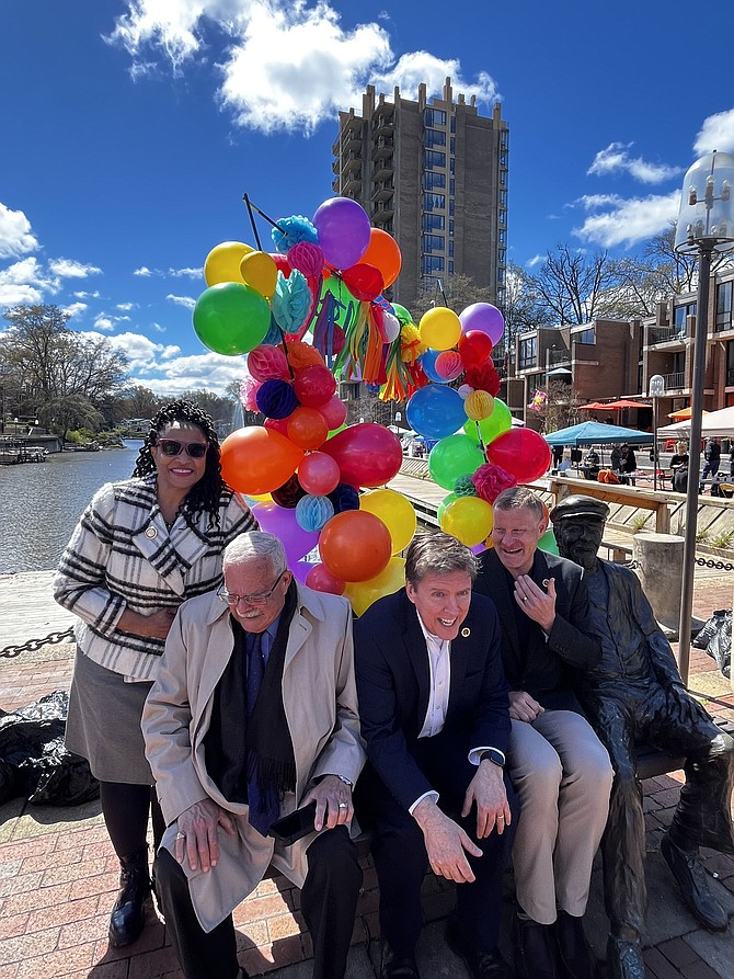 Del. Karen Keys-Gamarra (D-7), U.S. Rep. Gerry Connolly (D-11), Supervisor Walter Alcorn (D), and Chairman Jeff McKay (D) squeeze together moments before the Founder's Day 20th anniversary celebration in Reston on April 6. They want to be near 'Bronze Bob' by Zachary Oxman on Lake Anne Plaza. "Bronze Bob," whose official name is "Untold Stories," honors Reston's founder, Robert E. Simon (April 10, 1914–September 21, 2015).