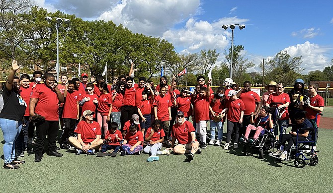 Players and volunteers gather for a group photo prior to the start of the Miracle of Alexandria game April 18 at the Kelley Cares Miracle Field.