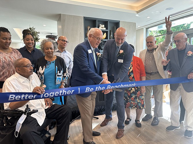 Benchmark Senior Living founder and CEO Tom Grape and Benchmark Alexandria executive director Doug Buttner, center, prepare to cut the ribbon at the grand opening celebration of Benchmark Alexandria May 2.