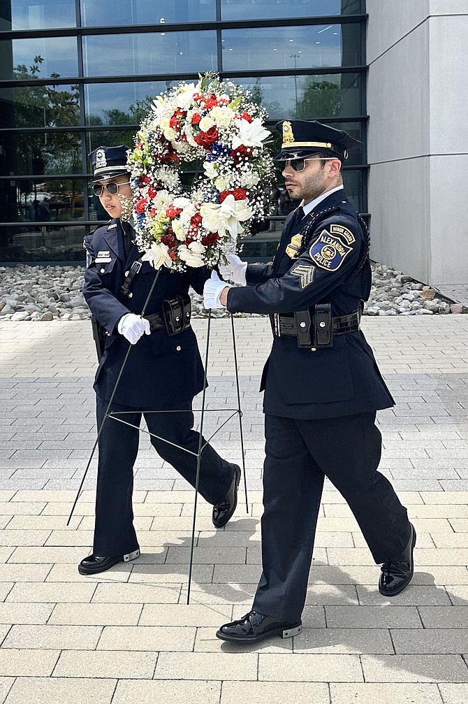 Alexandria police officers carry a wreath to place at the Fallen Officers Memorial in honor of slain Alexandria officers May 8 at APD headquarters.