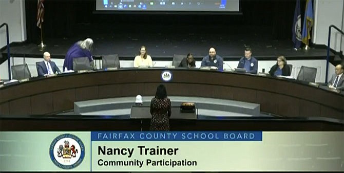 In 2024, Nancy Trainer testifies during the Fairfax County School Board Public Hearing on the FY 2025 Budget Hearing. In the video, viewers see only her back.
