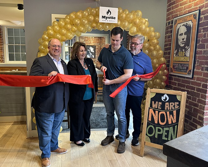 Ralph Davis, right, looks on as his son Matt cuts the ribbon to officially open Mystic BBQ and Grill May 10 on N. Lee Street. With them are Councilman Kirk McPike and Vice Mayor Amy Jackson.