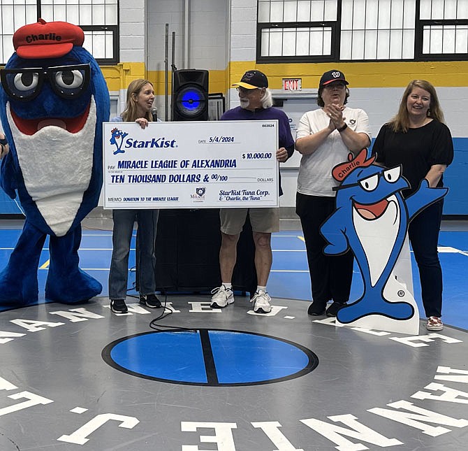 StarKist’s Charlie the Tuna helps Michelle Faist, head of Corporate Affairs for StarKist, present a check for $10,000 to Mac Slover, chair of the Miracle League of Alexandria, May 4 at the Nannie J. Lee Recreation Center. Also pictured are Laura Fries, VP of the Miracle League, and Allison McMahon, Assistive Technology and Specialized Instructional Specialist of the ACPS Office of Specialized Instruction.