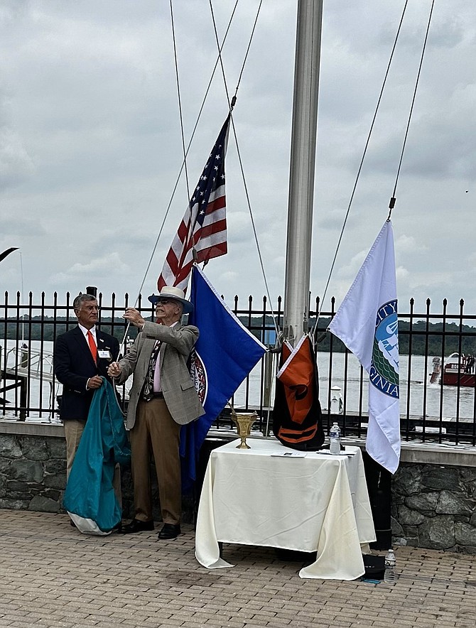 Army veteran and retired District of Maryland U.S. Marshall Johnny Hughes, right, raises the U.S. flag at the annual Flag Raising ceremony May 19 at the Old Dominion Boat Club. Looking on is ODBC Commodore Art Barletta.