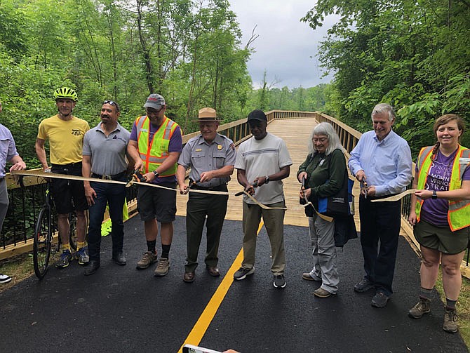 George Washington Memorial Parkway Superintendent Charles Cuvelier hosted a ribbon cutting on May 19 for the bridge across Dyke Marsh on the Mount Vernon Trail, a bridge that replaces one that was nearing the end of its useful life. Glenda Booth, Supervisor Dan Storck (in yellow with bike helmet) and U.S. Rep. Don Beyer (in blue shirt) joined in.
