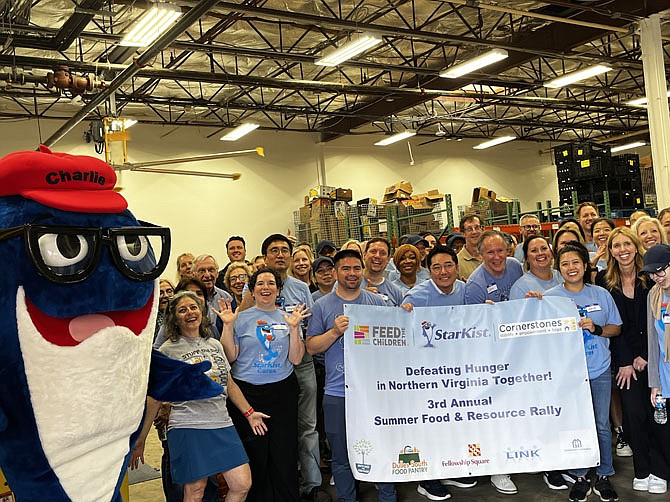 Staff and volunteers from various organizations and businesses gather before distributing more than 100,000 pounds of food and household essentials to five Dulles Corridor regional food pantries and nonprofits.