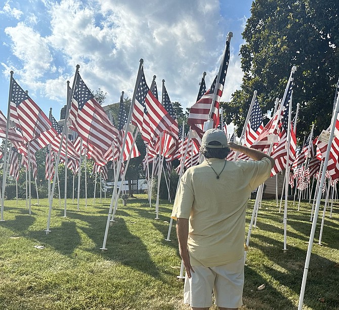 Jon Miller of Leesburg salutes while visiting the Flags For Heroes display June 30 at Cedar Knoll Restaurant.