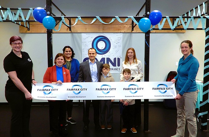 Cutting the ribbon are (from left) head massage therapist Sara Reynolds, Catherine Read, Tara Borwey (Fairfax City Economic Development), Jose Chacón, wife Jennifer Tillman and their sons Liam, 10, and Julian, 8, and Dr. Courtney Dagan, head of physical therapy.