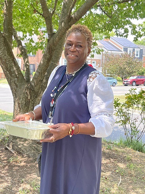 Rhonda Bilal, a Lead RSS & Program Assistant at Guest House, comes out to help carry the marinated cucumber salad.