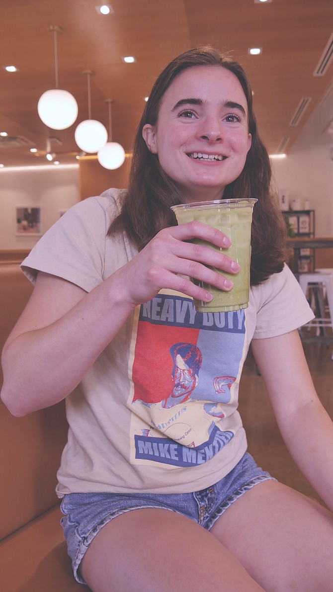 Cheyenne Klapper sits at Compass Coffee drinking her green Matcha, made with powdered dried green tea leaves and mixed with oat milk.