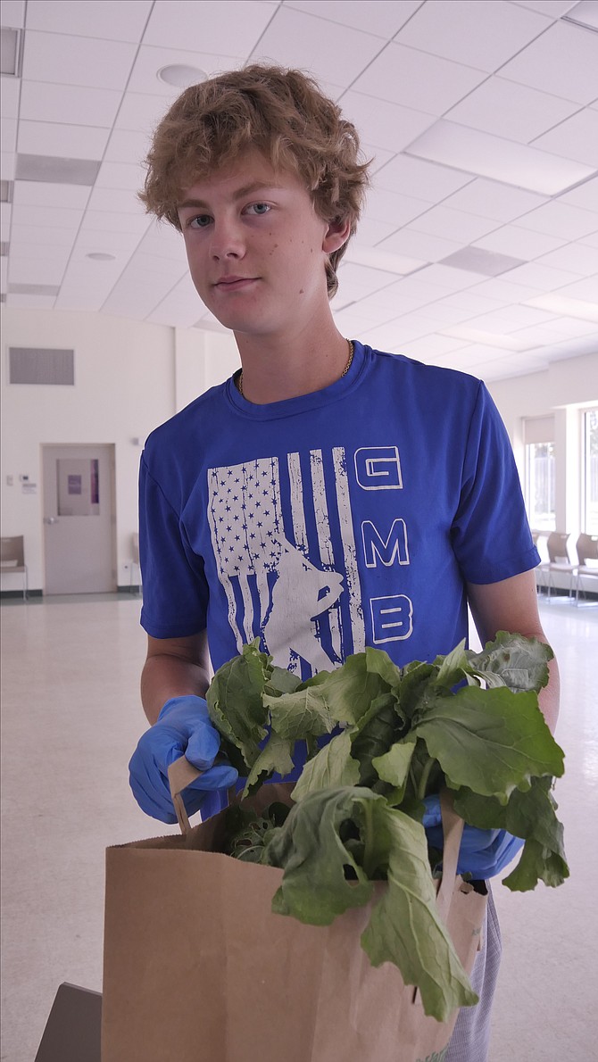 Jay Currle bags zucchini and collard greens for needy families on Monday at Rock Spring UCC.