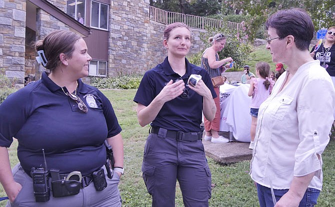 Harley Guenther and Audrey Lieb, members of the ACPD Community Engagement unit chat with Helen Ignatenko, the new branch manager, who is part of the library team welcoming people to National Night out.