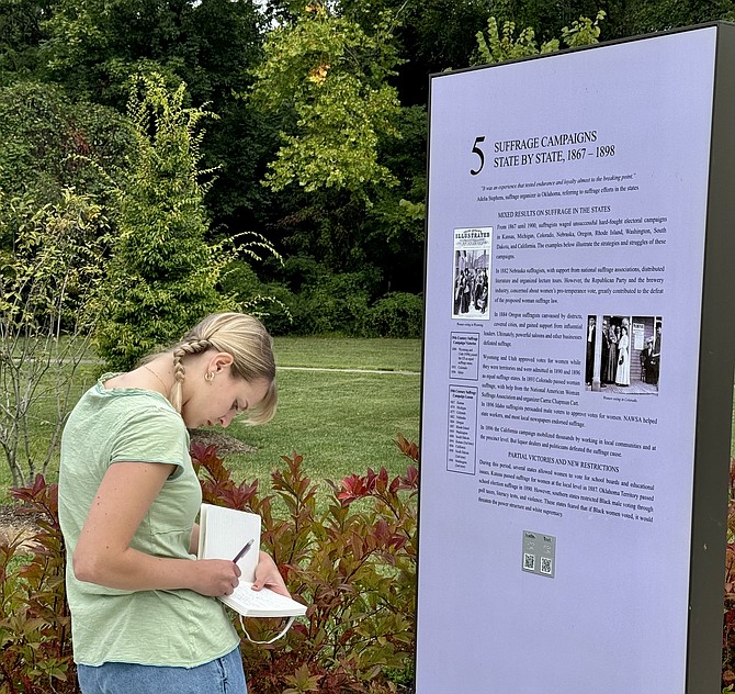 Research assistant Sydney Worrell takes notes at one of 19 informational panels at the Turning Point Suffragist Memorial, as fact check before a book publication.